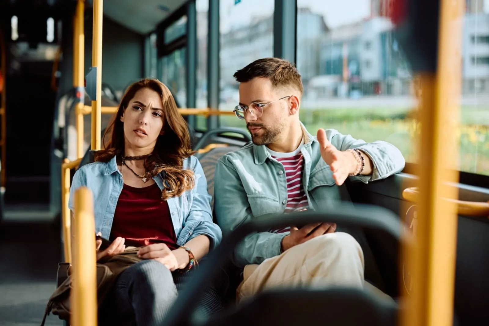 Ein Mann und eine Frau sitzen in einem Bus und unterhalten sich