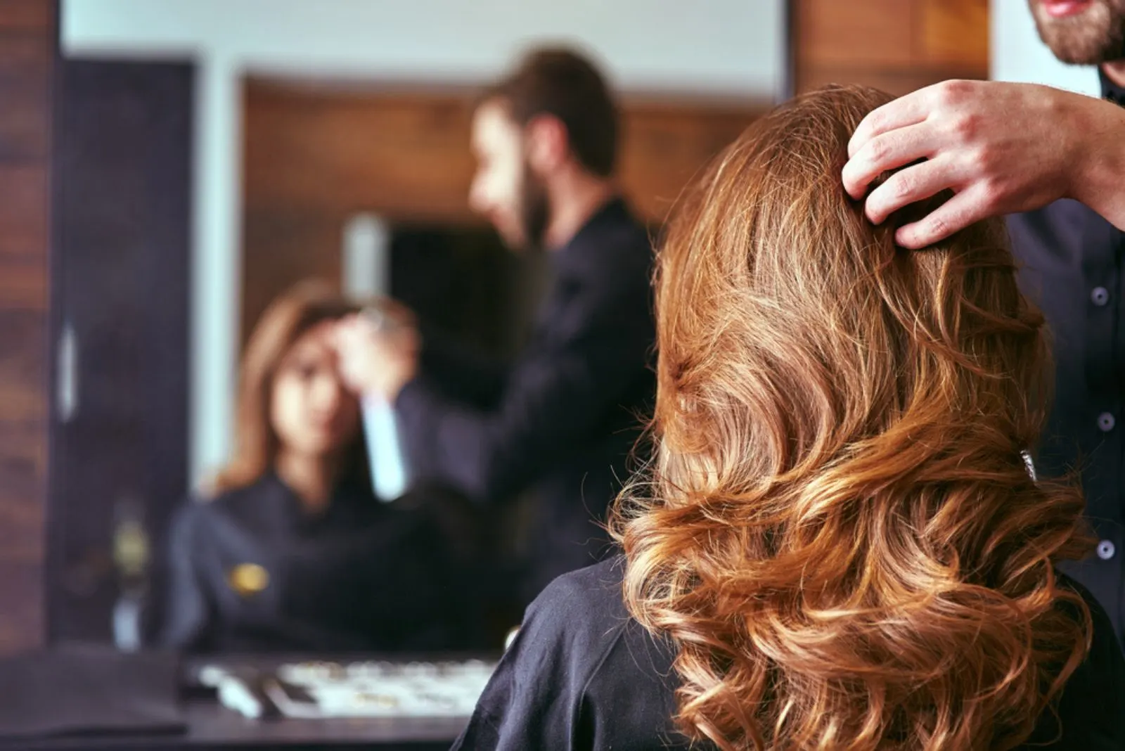 Eine Frau repariert ihre Haare beim Friseur