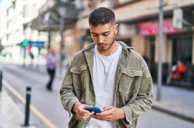 Ernster Mann, der am Telefon tippt