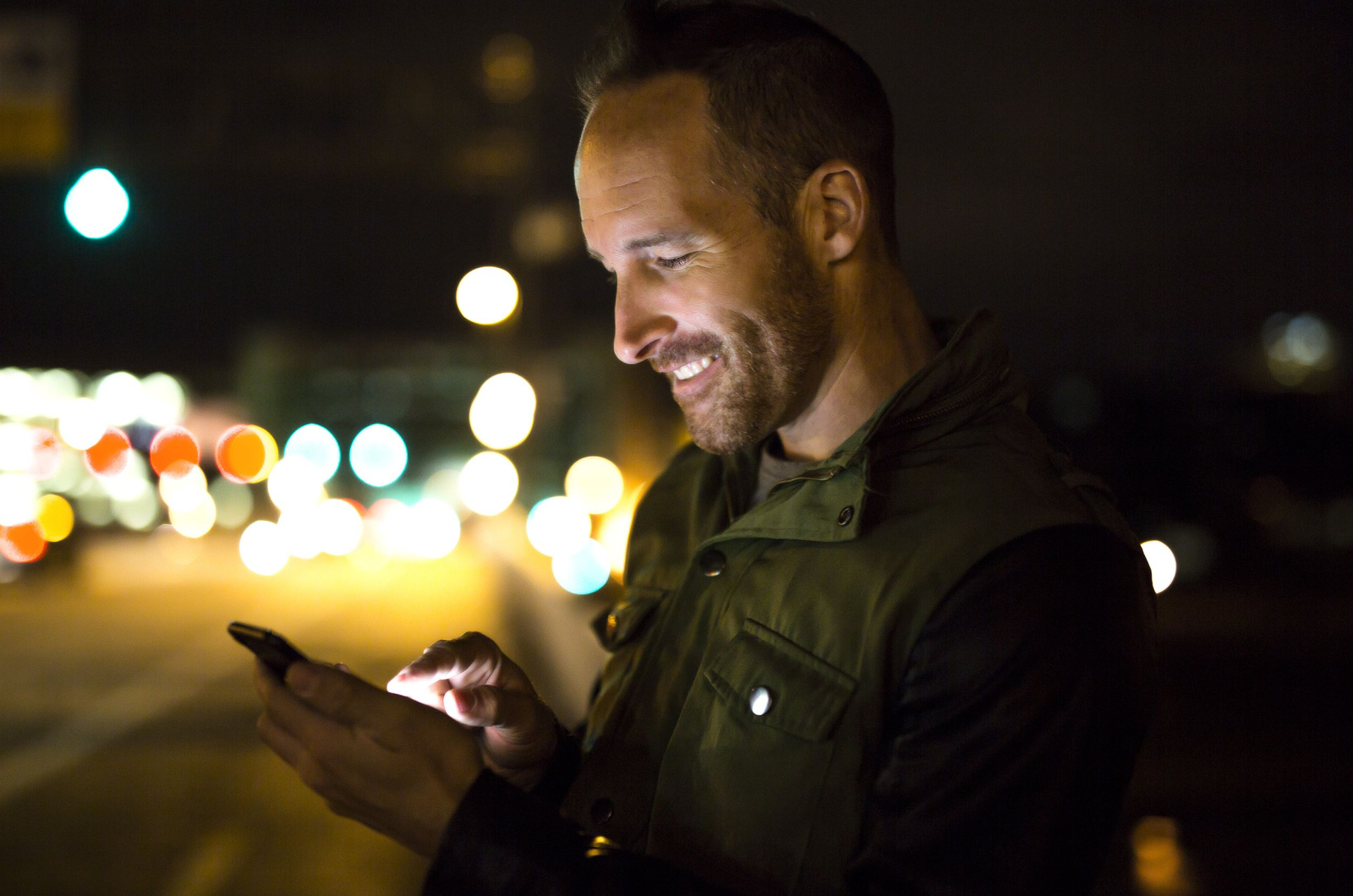 Mann benutzt nachts Smartphone-Handy in der Stadt
