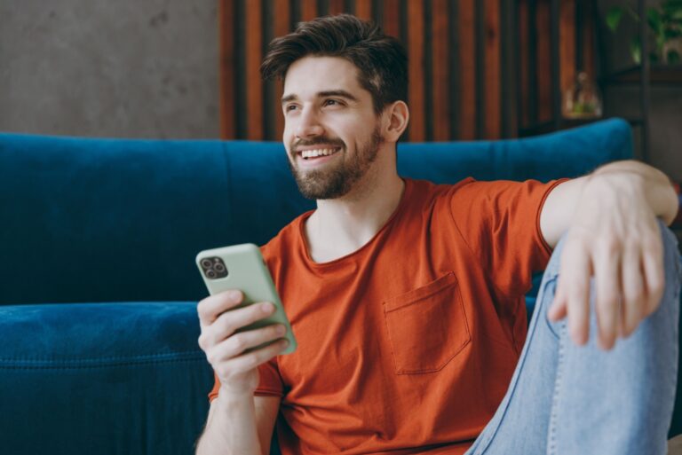 Mann haelt sein Telefon