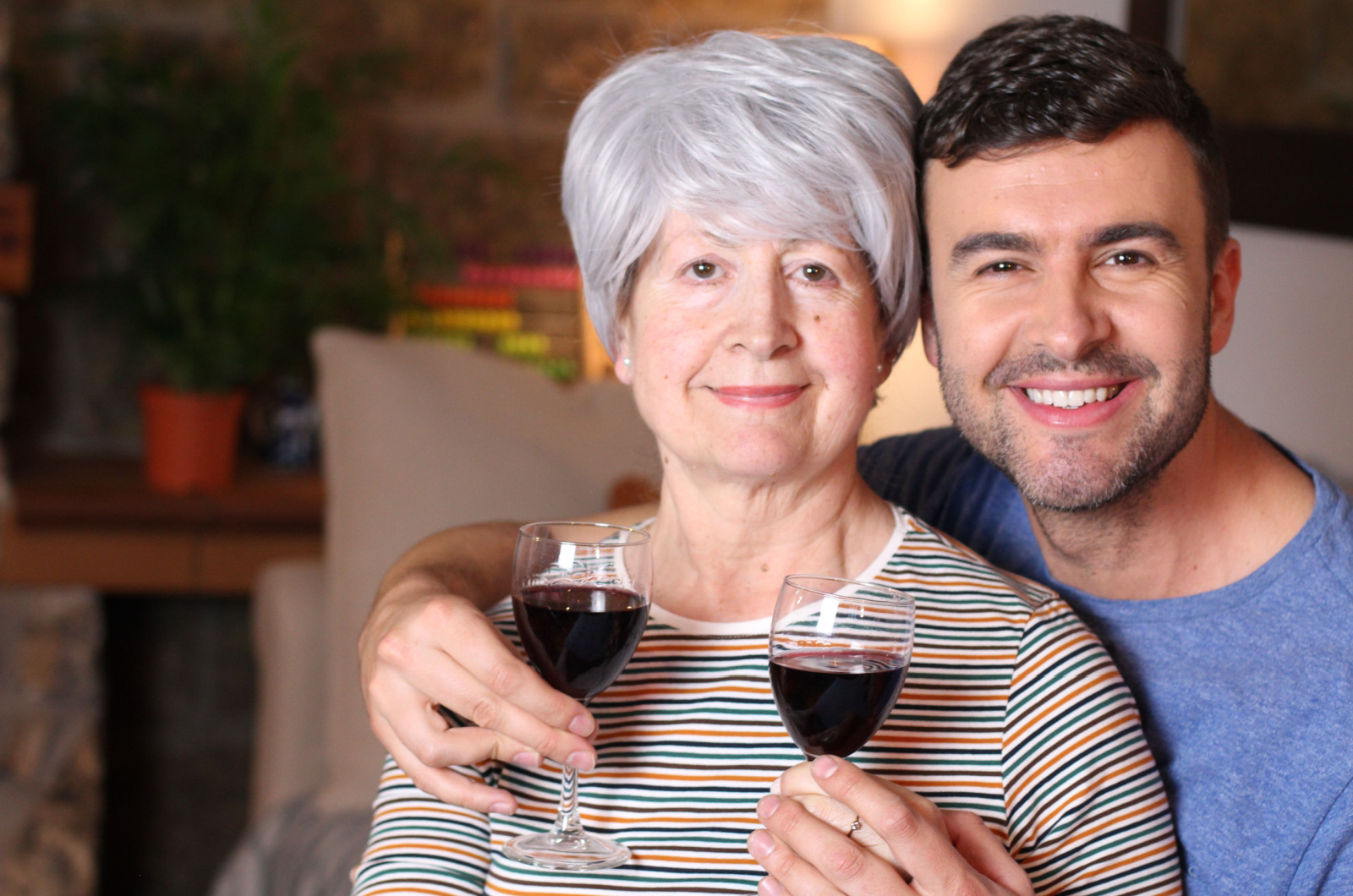 junger Mann und ältere Frau trinken Wein