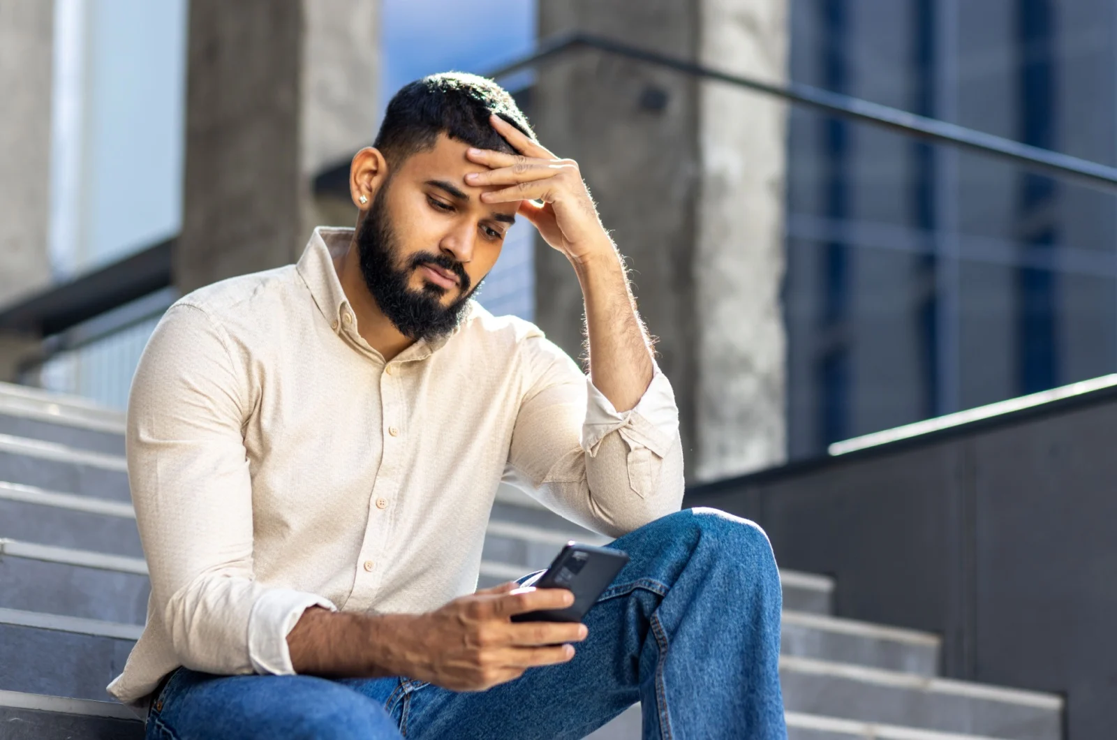 trauriger Mann tippt am Telefon