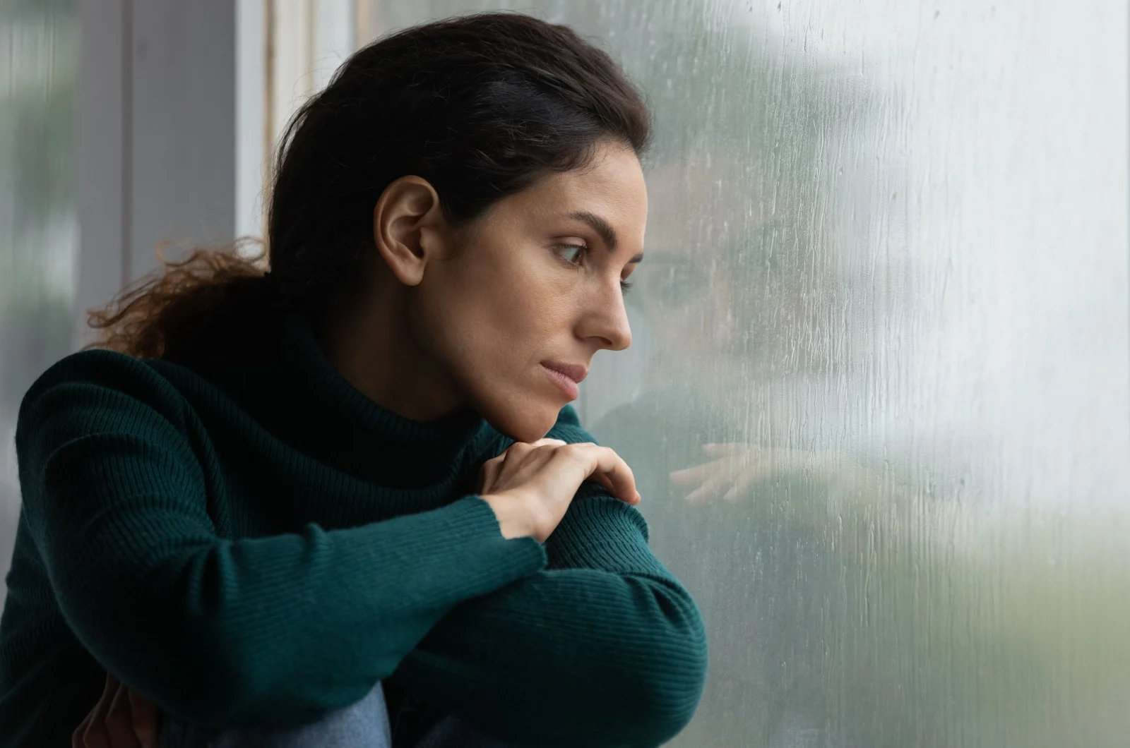 traurige Frau schaut aus dem Fenster