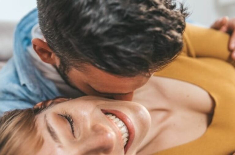 Mann kuesst Frau im Nacken