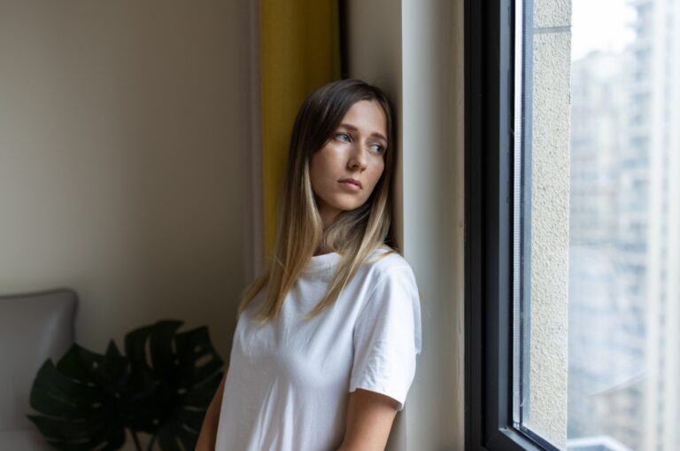Traurige Frau, die durch das Fenster schaut