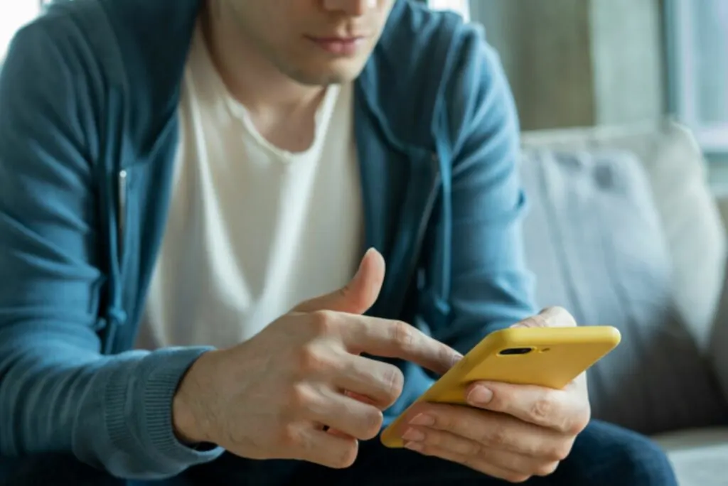 Der Mann schaut auf das Telefon