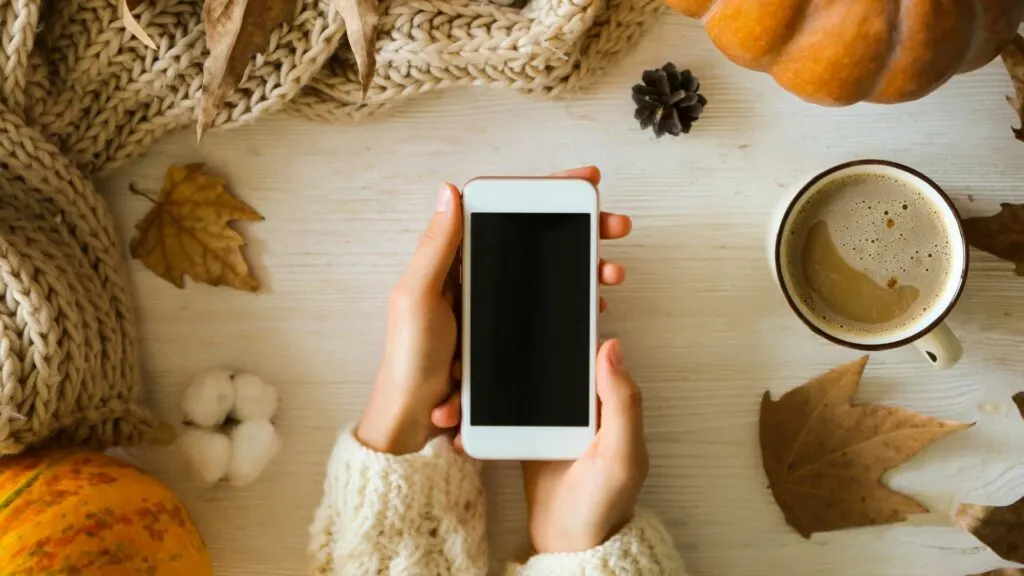 Die Frau laesst das Telefon auf dem Tisch liegen