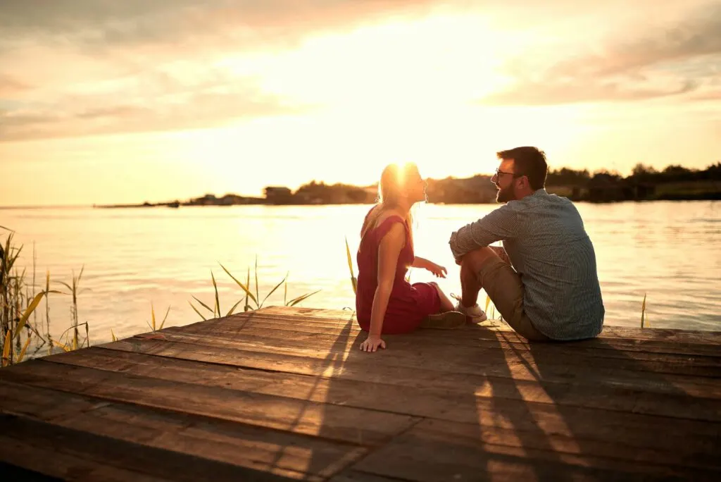 Ein Liebespaar sitzt auf dem Pier und redet