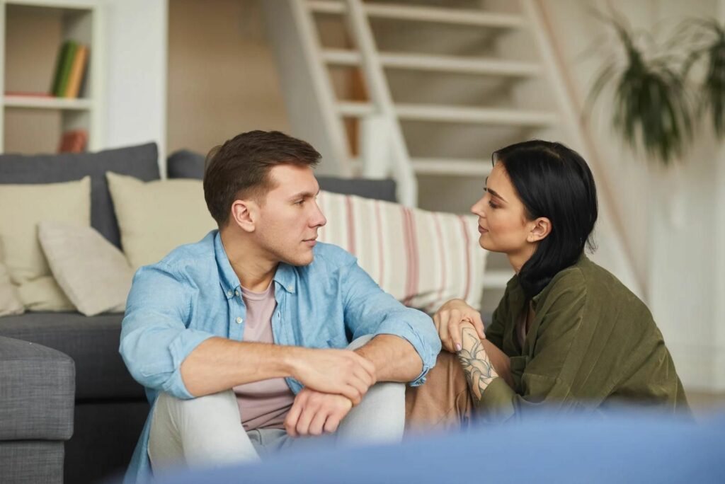 Ein Mann und eine Frau sitzen nebeneinander und unterhalten sich