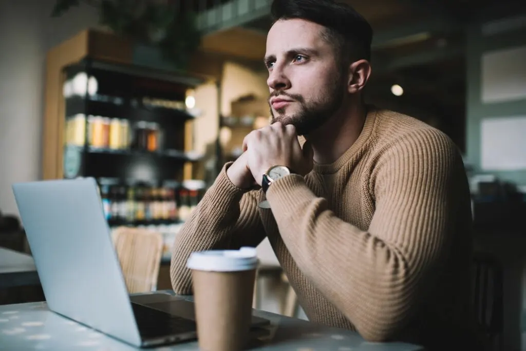 Ein nachdenklicher Mann sitzt in einem Café an einem Tisch