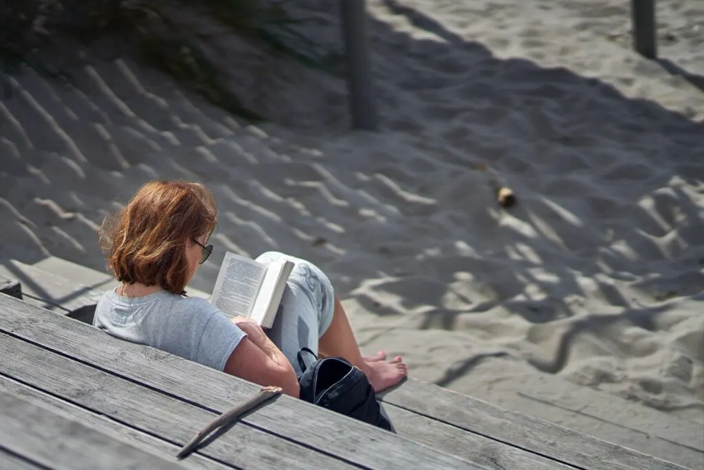 Eine Frau sitzt auf einer Bank und liest ein Buch