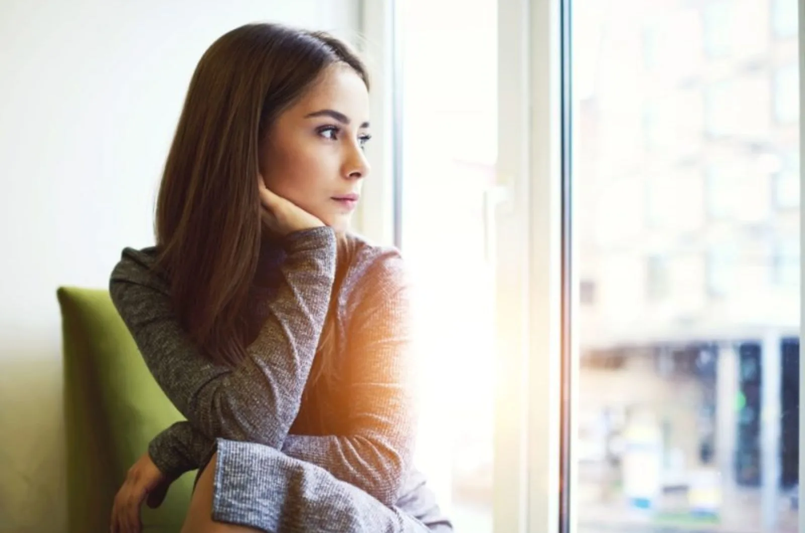 Frau schaut durch Fenster