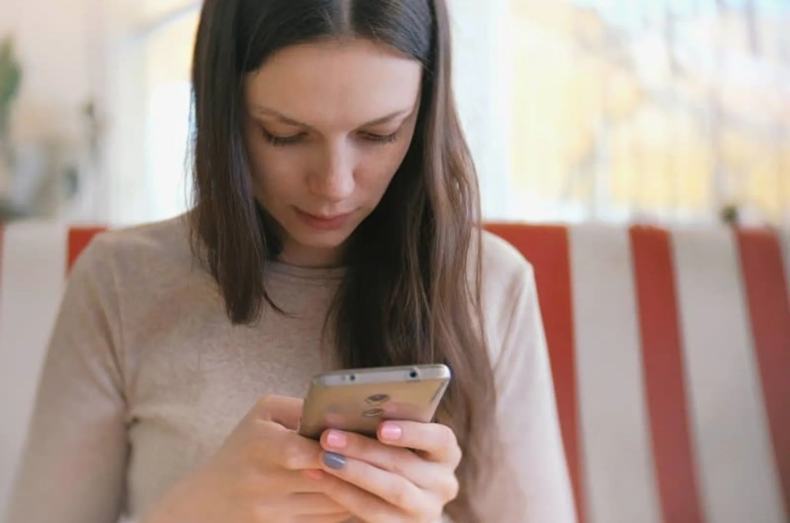 Frau tippt am Telefon