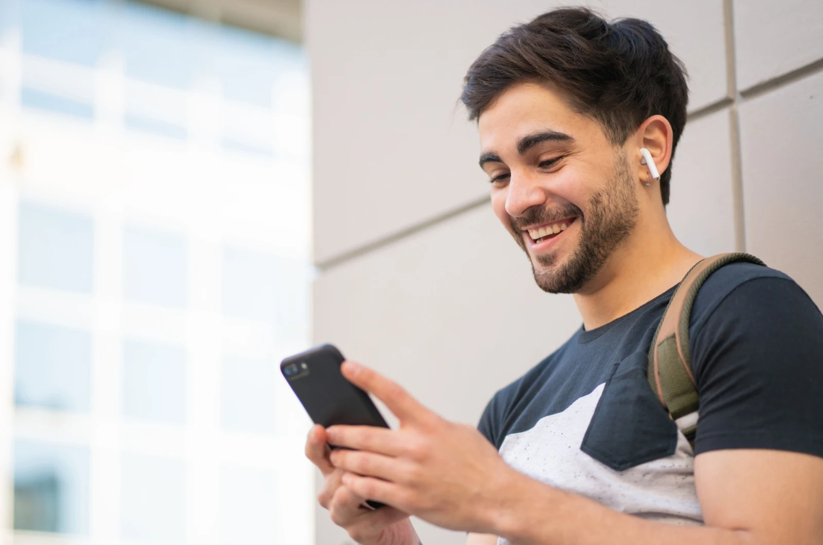 Mann laechelt und haelt ein Telefon