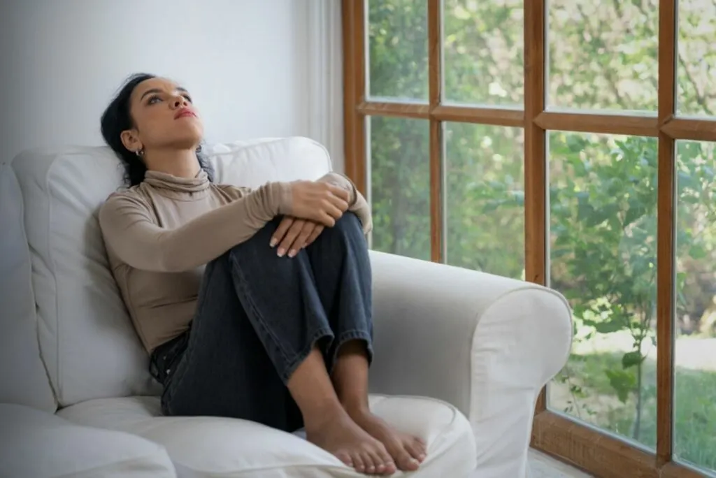 Nachdenkliche Frau liegt auf der Couch