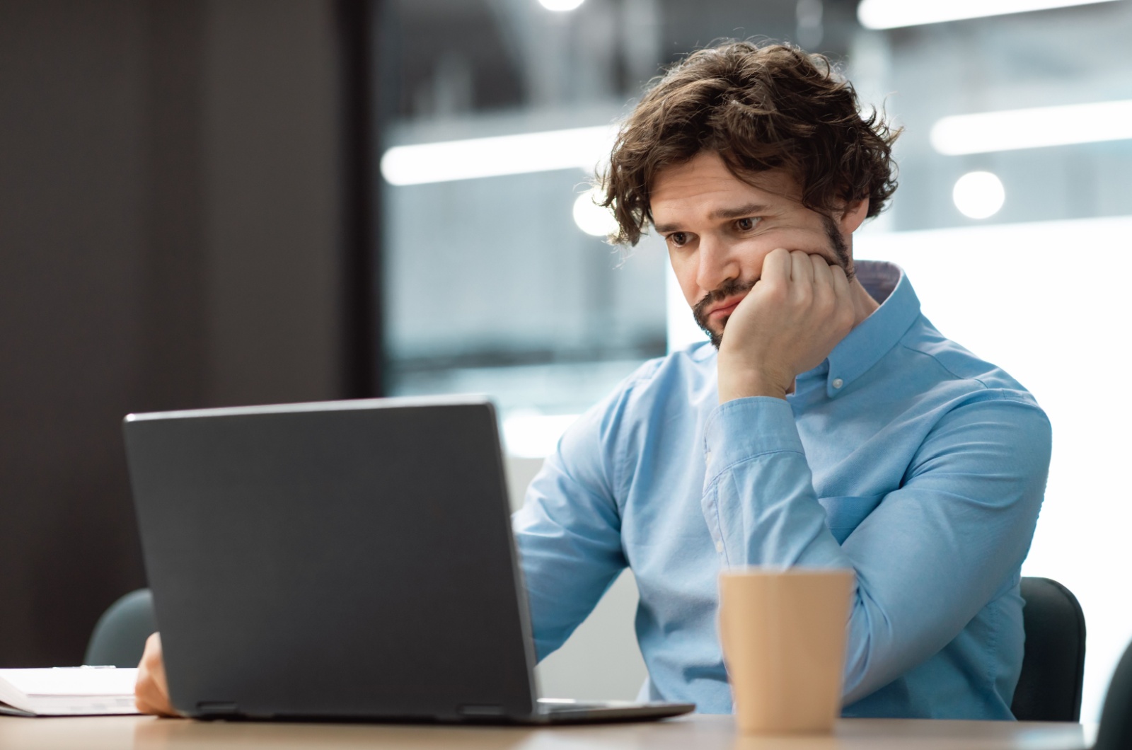 Trauriger Mann der auf Laptop schaut