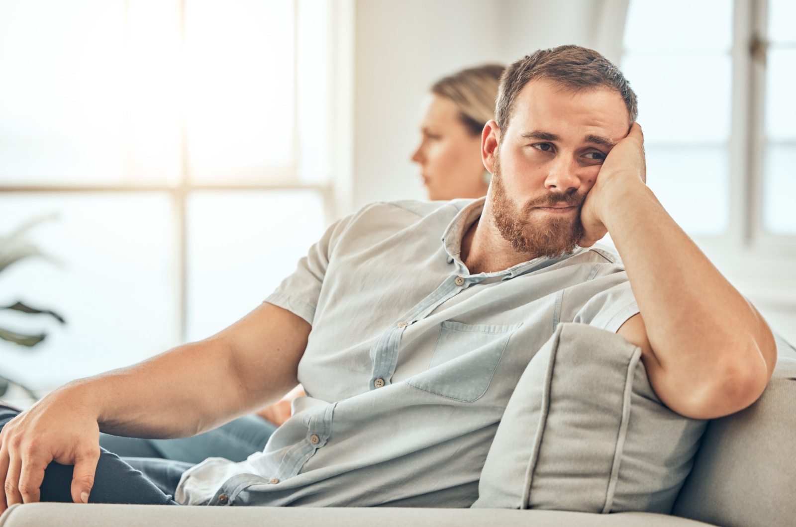 Trauriger Mann sitzt auf der Couch