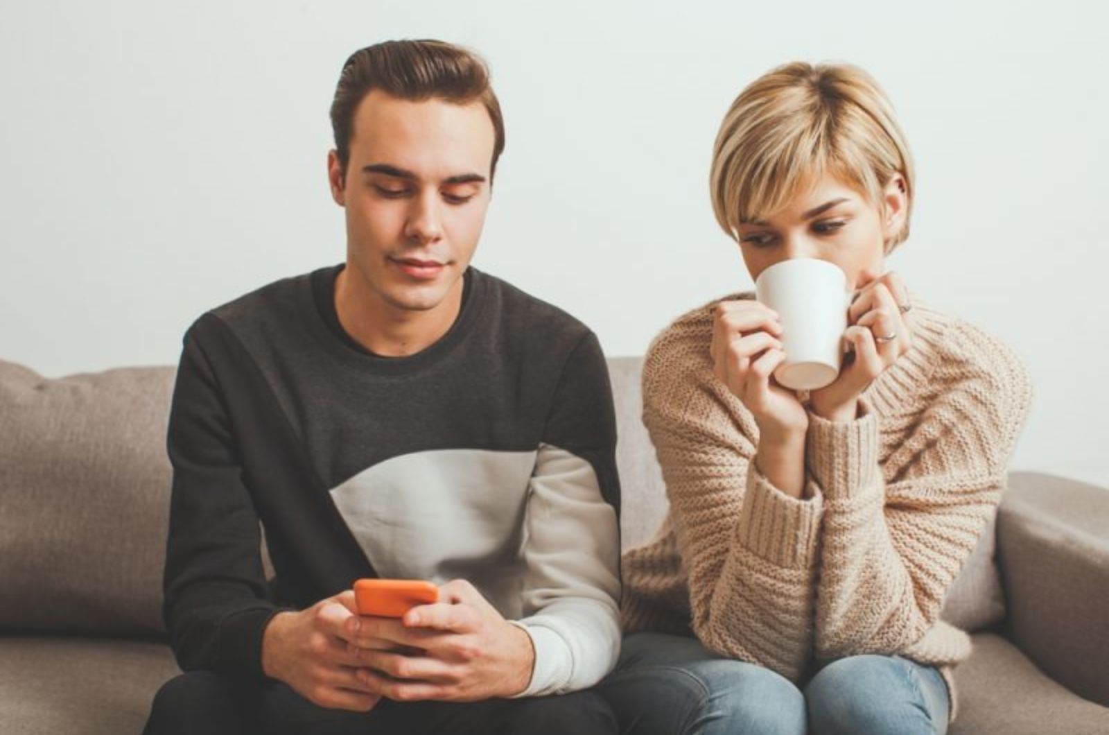 eifersuechtige Frau schaut auf das Telefon des Mannes