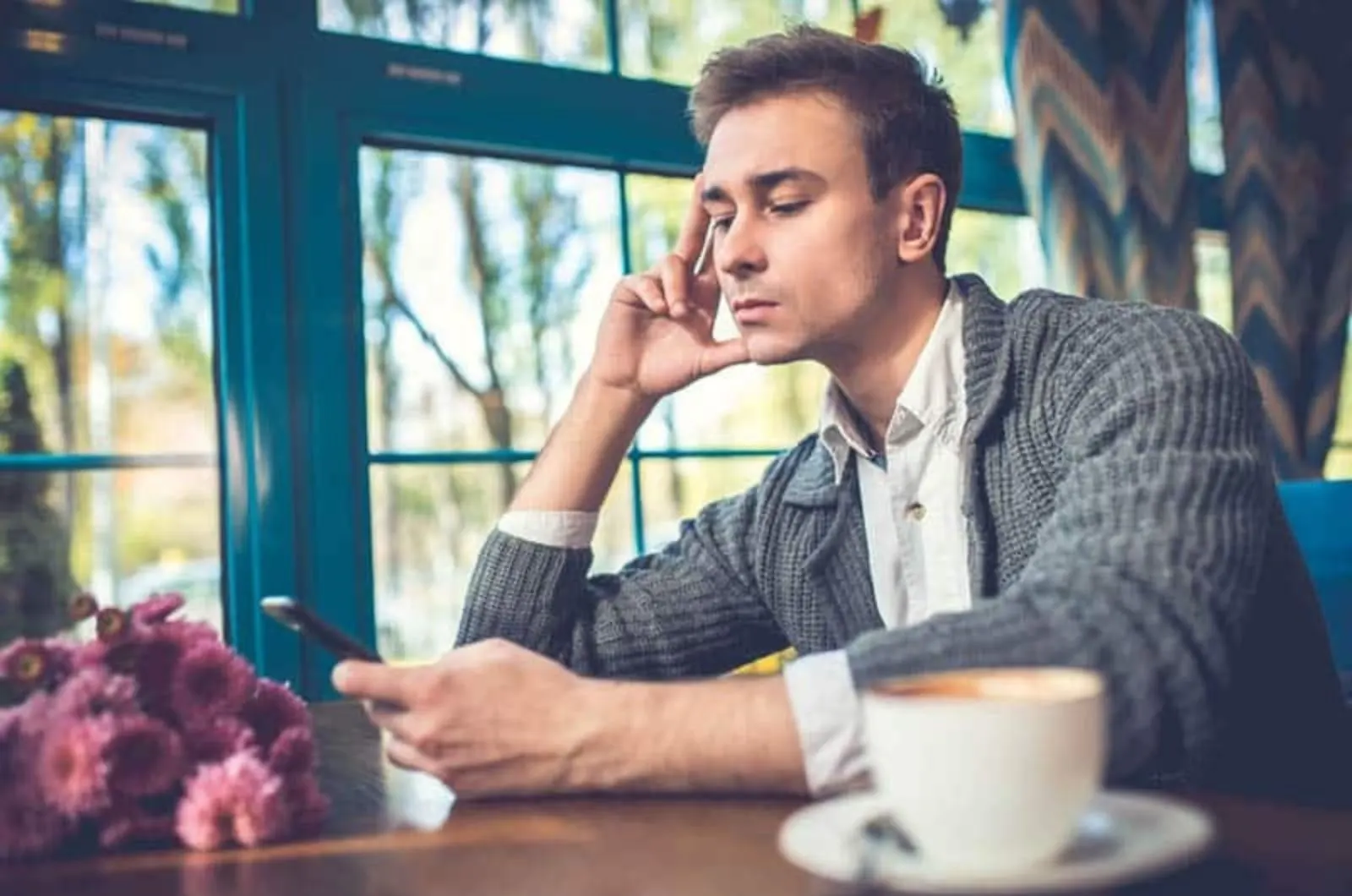 gelangweilter Mann mit Telefon