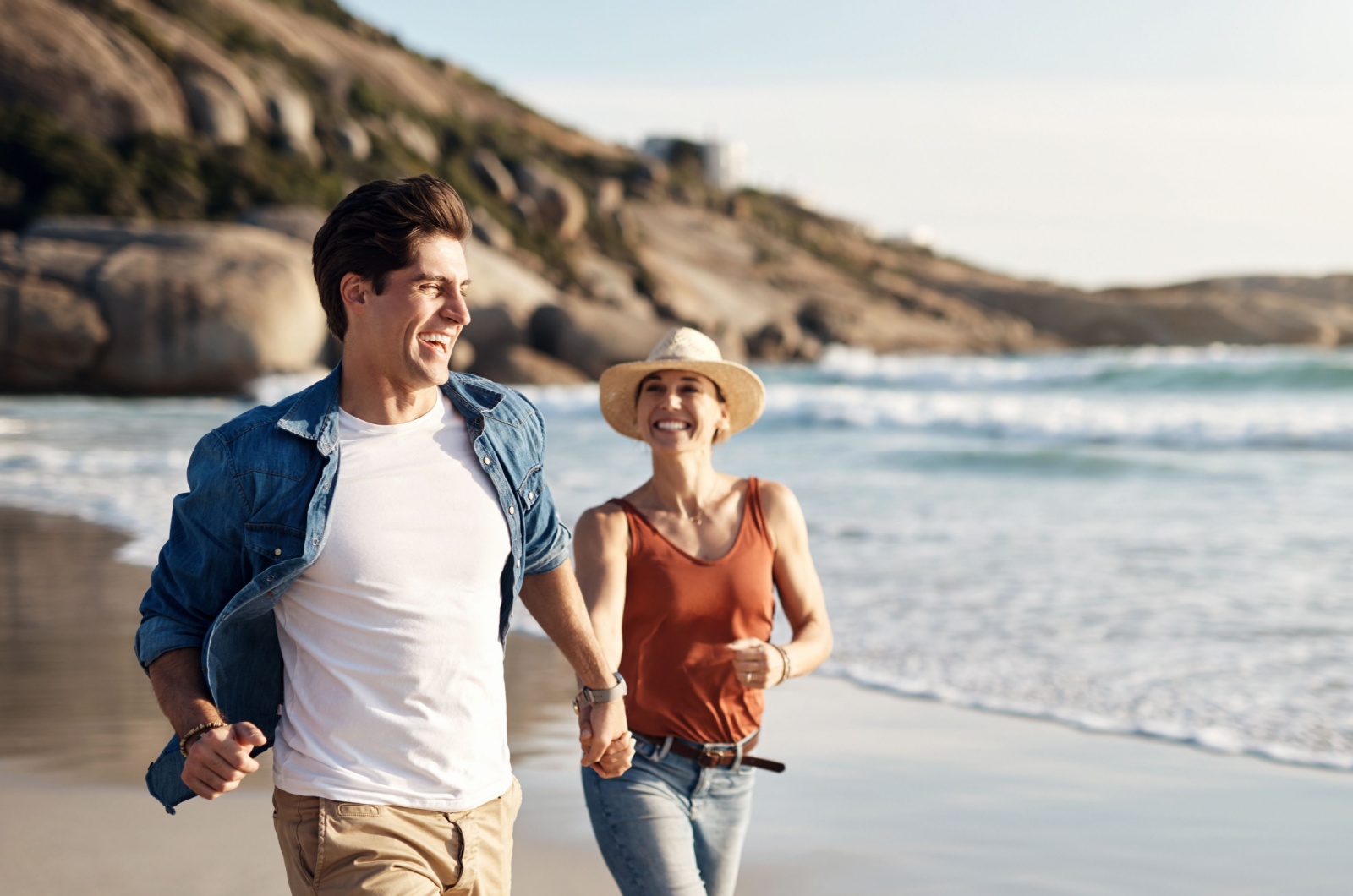 glueckliches Paar laeuft am Strand