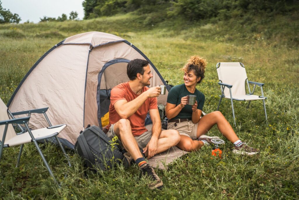 Ein Mann und eine Frau sitzen im Gras und unterhalten sich