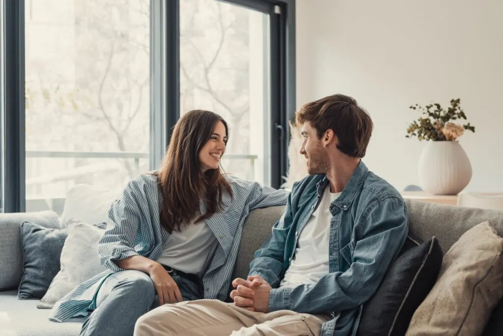 Ein leidenschaftlich liebendes Paar sitzt auf der Couch und redet