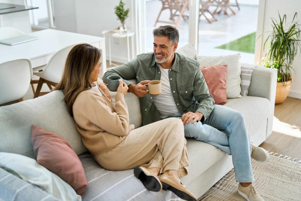 Laechelnder Mann und Frau reden auf der Couch