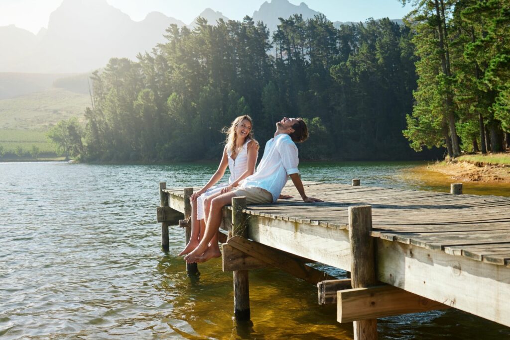 Laechelndes Paar sitzt am Pier