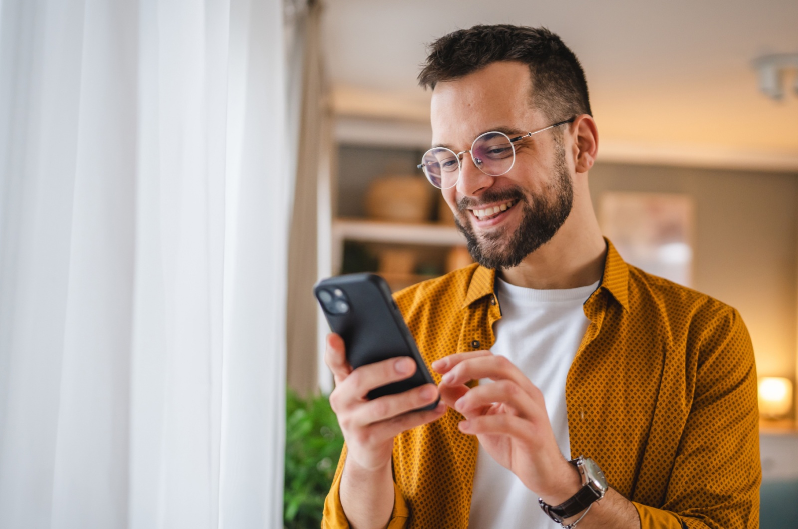 Mann schreibt SMS am Telefon