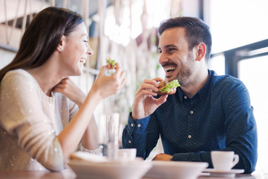 laechelnder Mann und Frau beim Essen