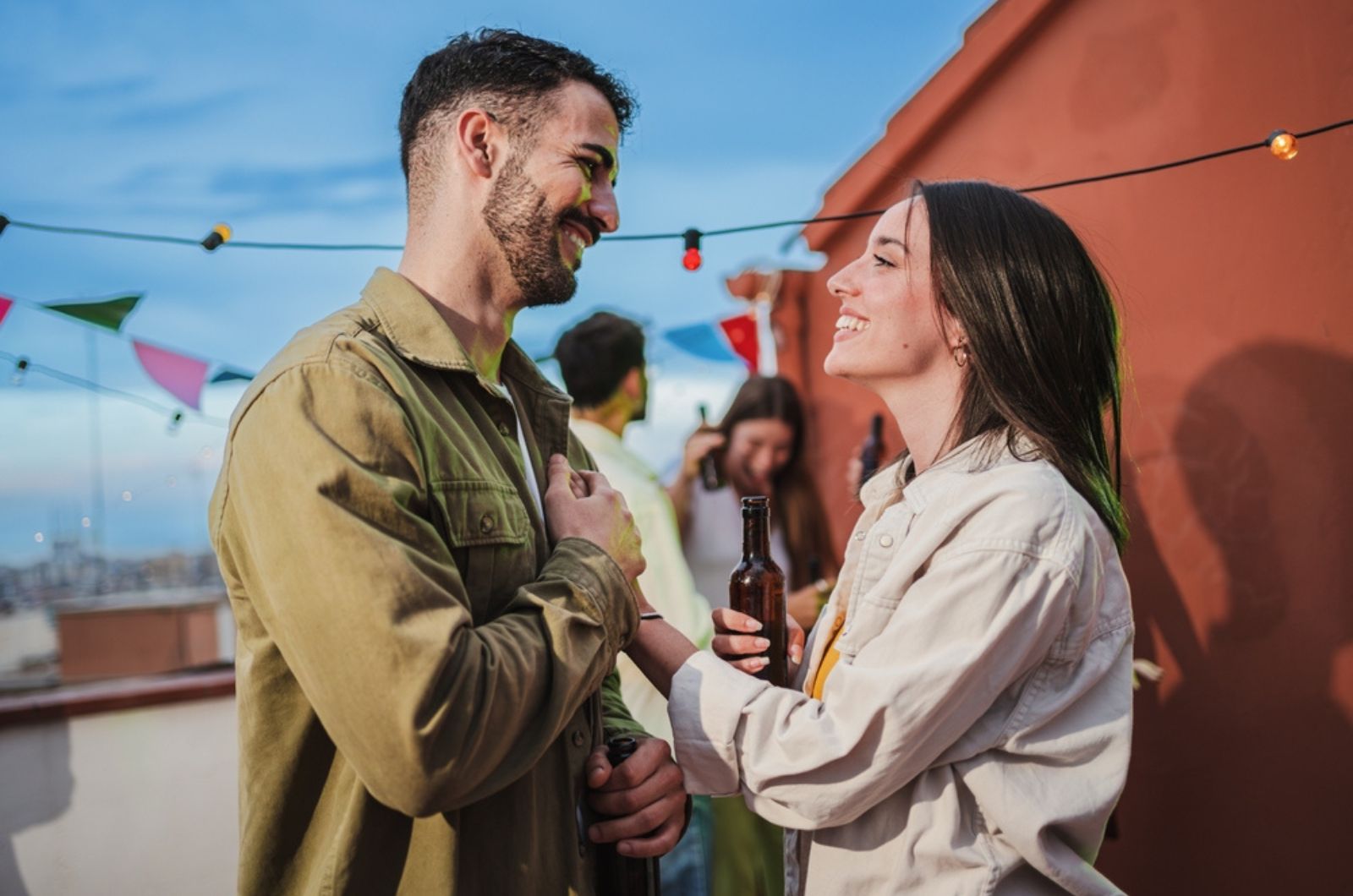 Laechelnder Mann und Frau, die auf der Party reden