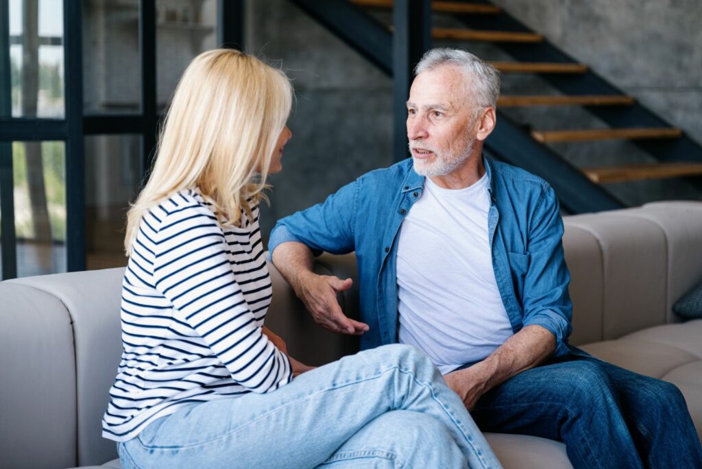 Ein Mann sitzt neben einer Frau auf einer Couch