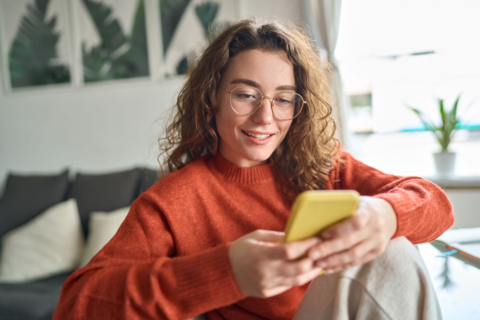 Ein Mädchen mit zerzausten Haaren tippt am Telefon