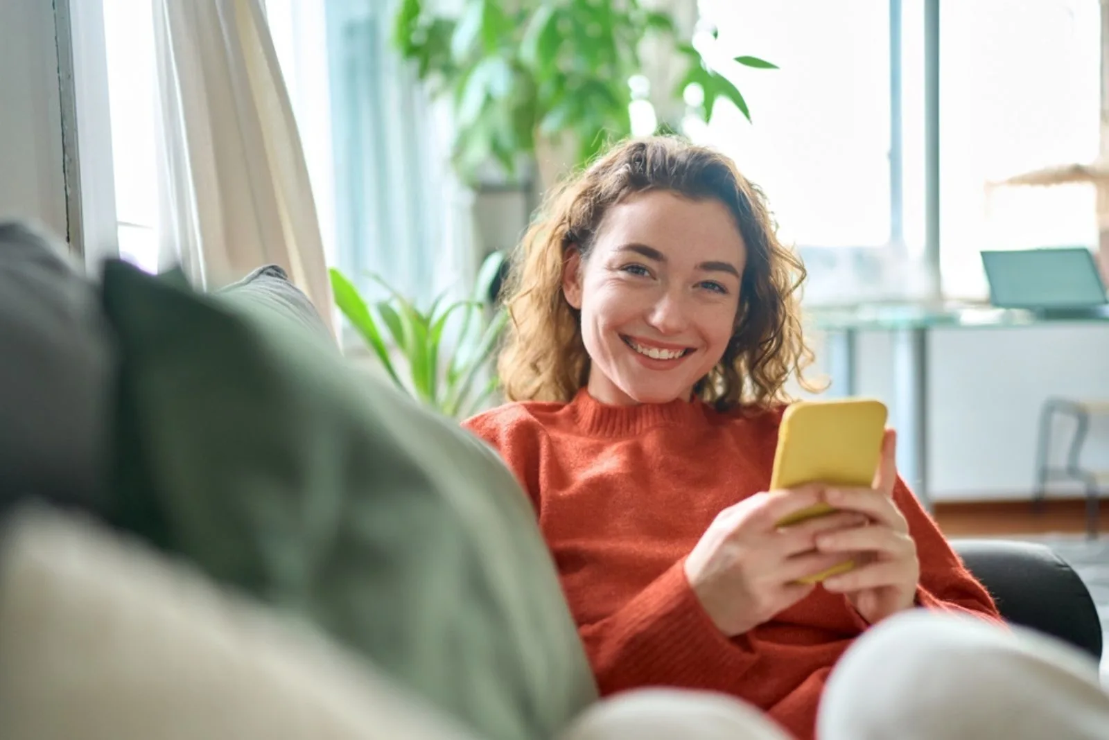 laechelnde Frau mit Handy in der Hand