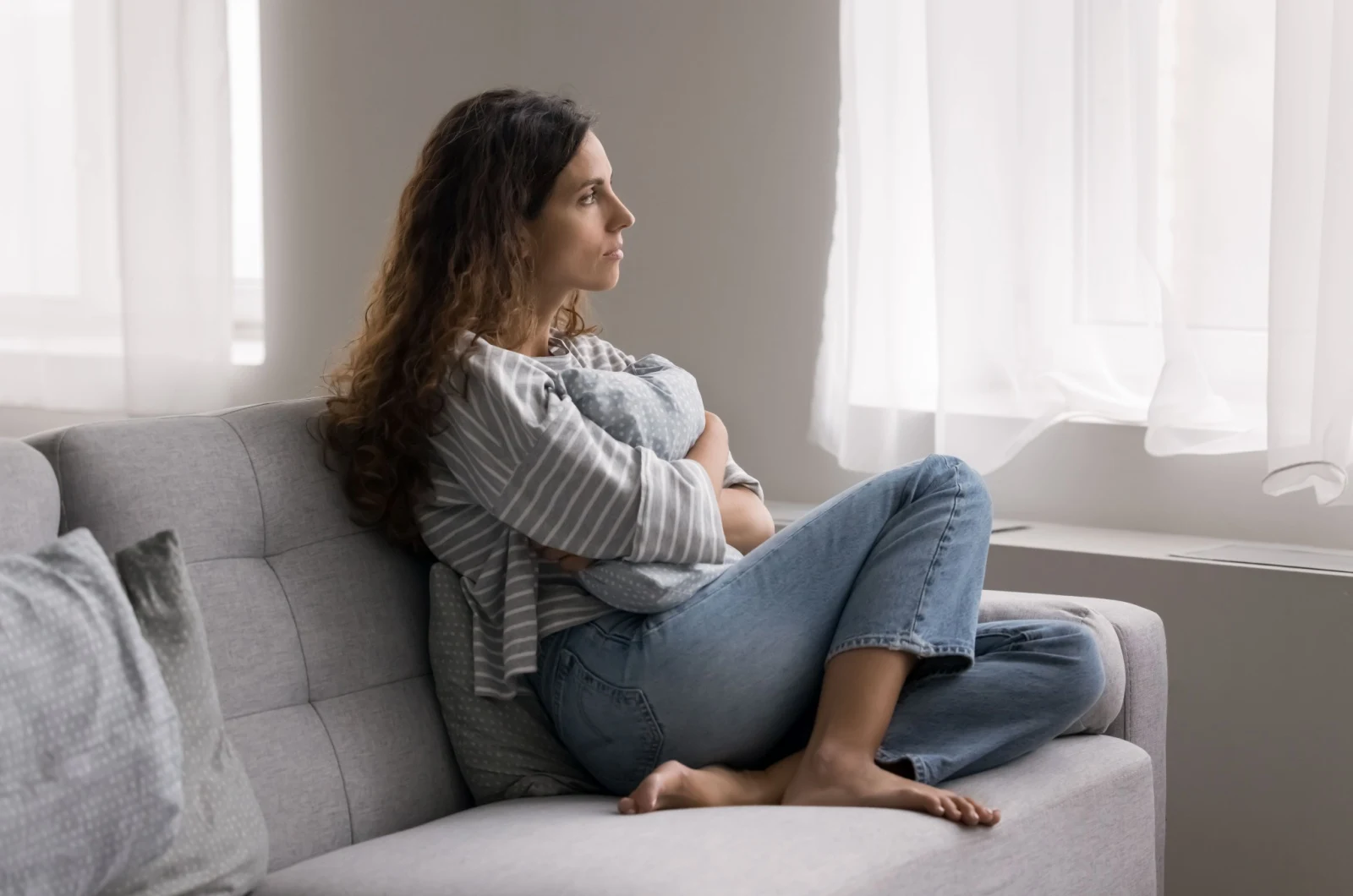 traurige Frau sitzt auf der Couch