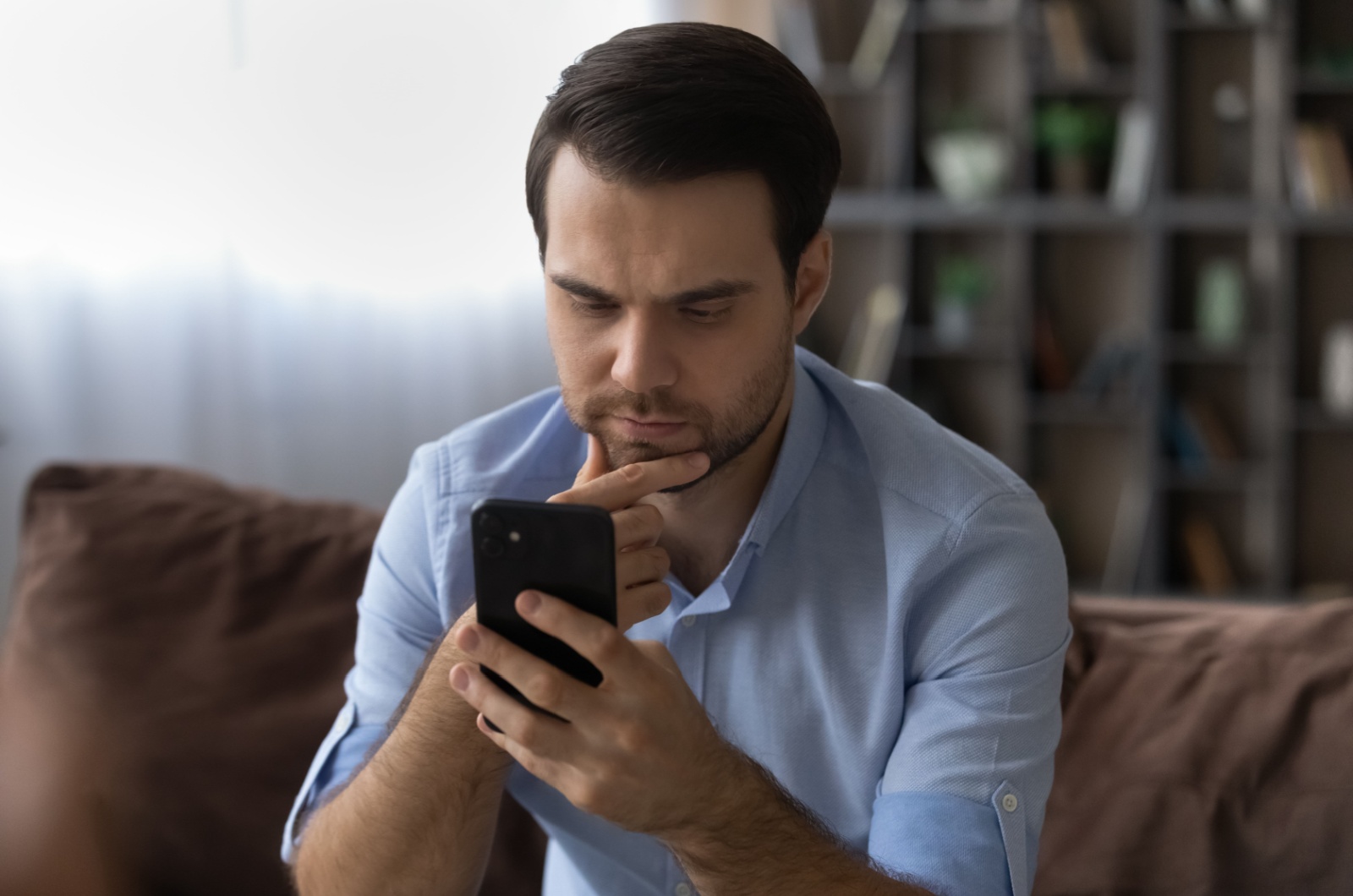 Besorgter Mann schaut auf sein Telefon