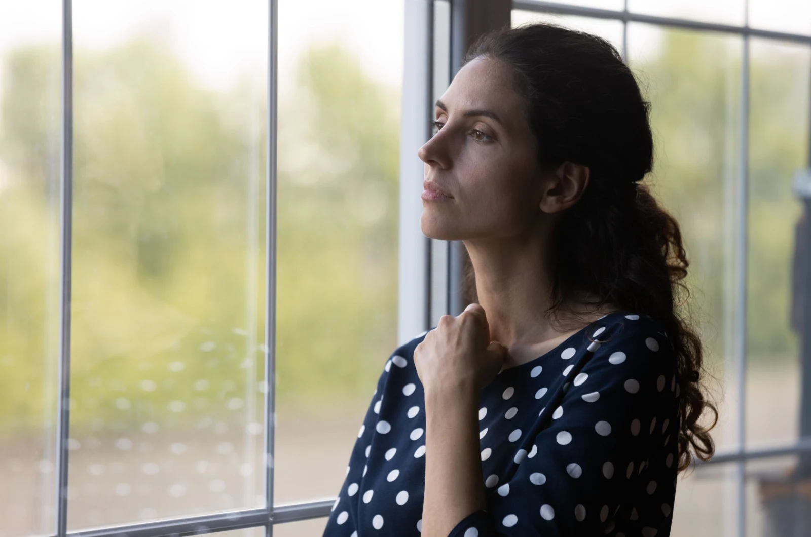 traurige Frau schaut aus dem Fenster