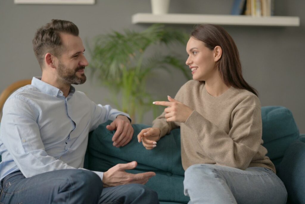 Ein Mann und eine Frau sitzen auf einer Couch und unterhalten sich