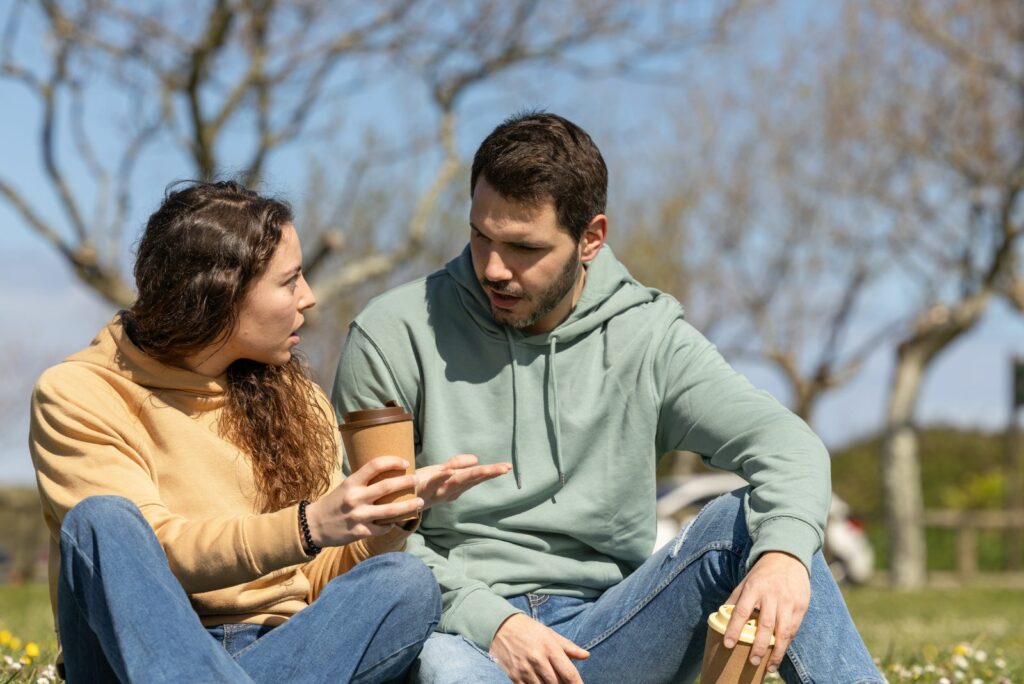 Ein Mann und eine Frau sitzen im Park und streiten