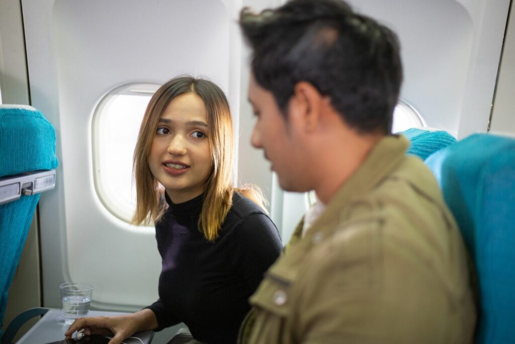 Ein Mann und eine Frau sitzen nebeneinander im Flugzeug