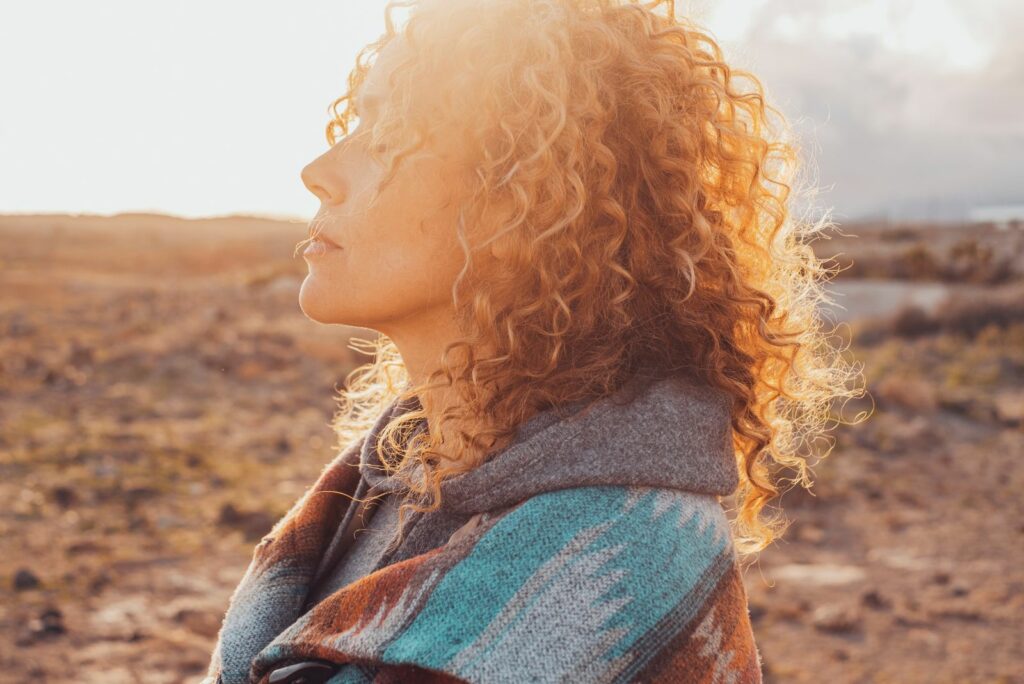 Eine Frau mit krausem Haar genießt die Sonne