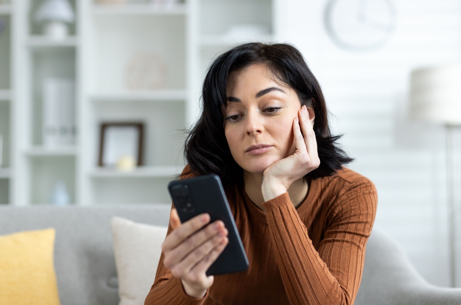 Traurige Frau schaut auf ihr Telefon