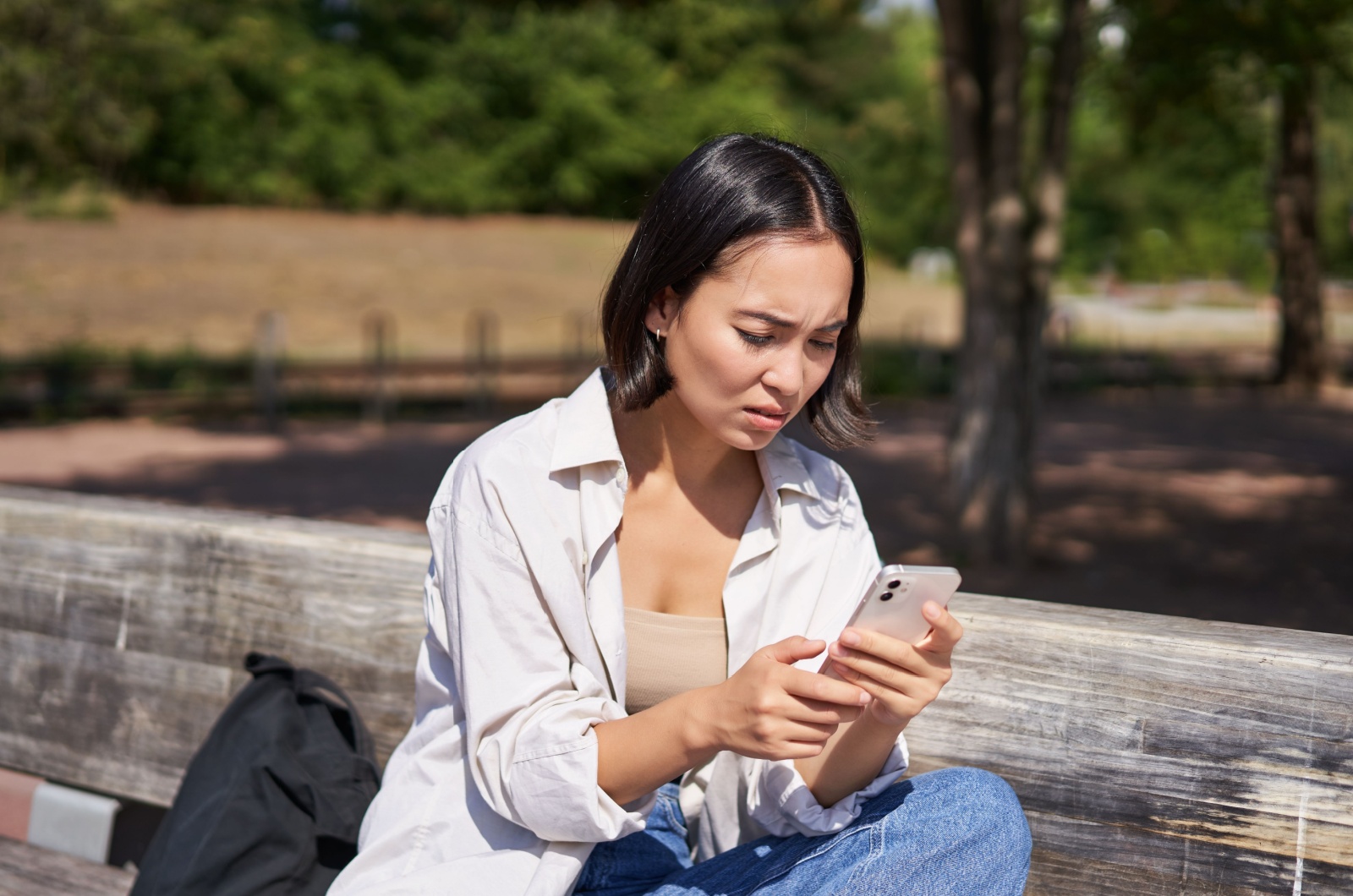 besorgte Frau, die auf ihr Telefon schaut