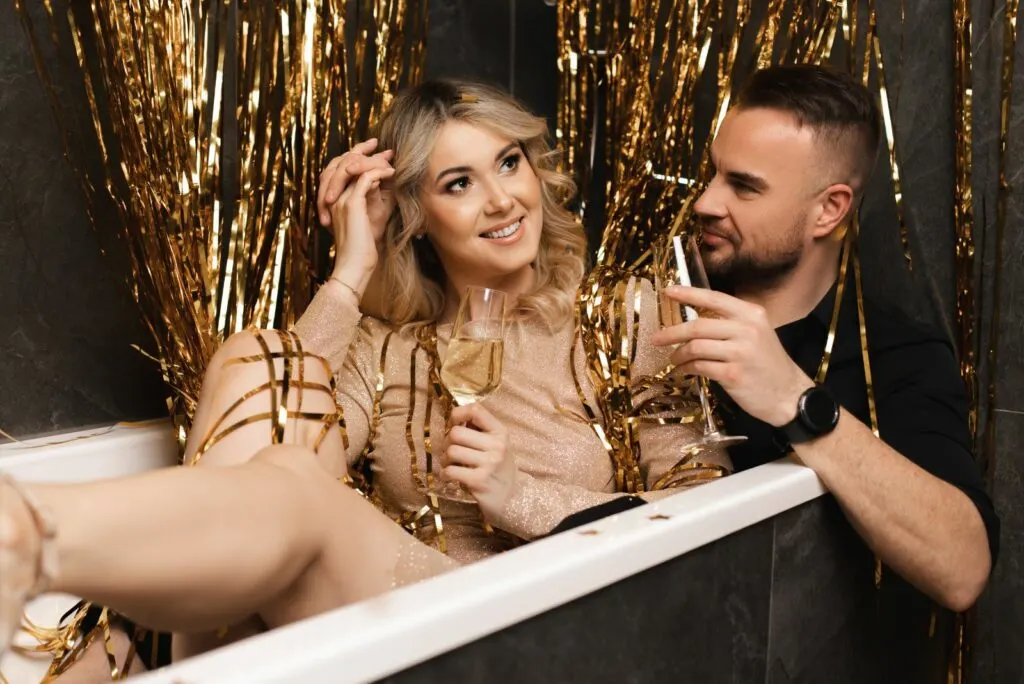 Ein Mann und eine Frau trinken Champagner in einer Badewanne