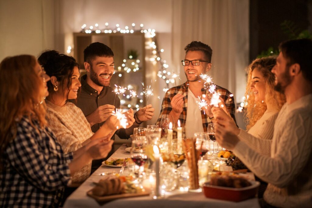 Freunde sitzen am Tisch und feiern das neue Jahr