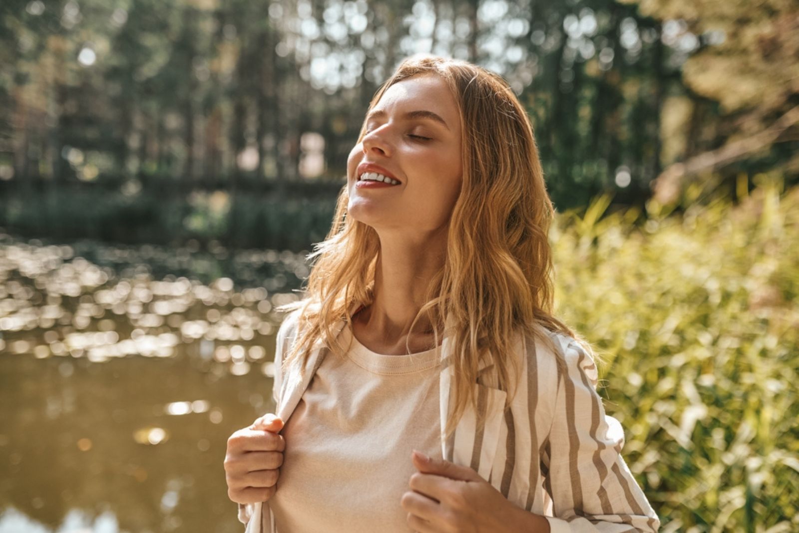 blonde Frau entspannt in der Natur stehen