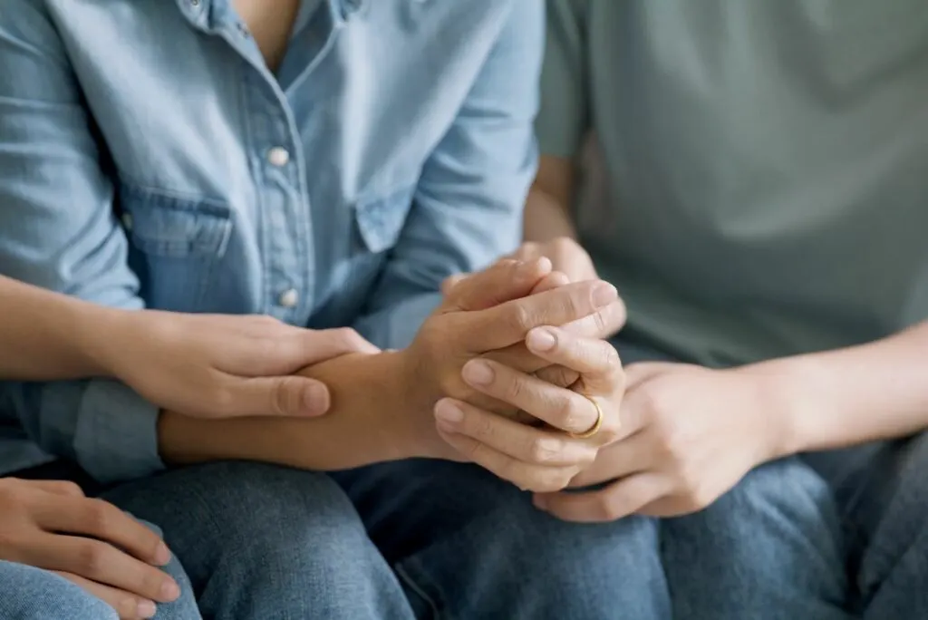 Sohn und Tochter halten die Hand ihrer Mutter