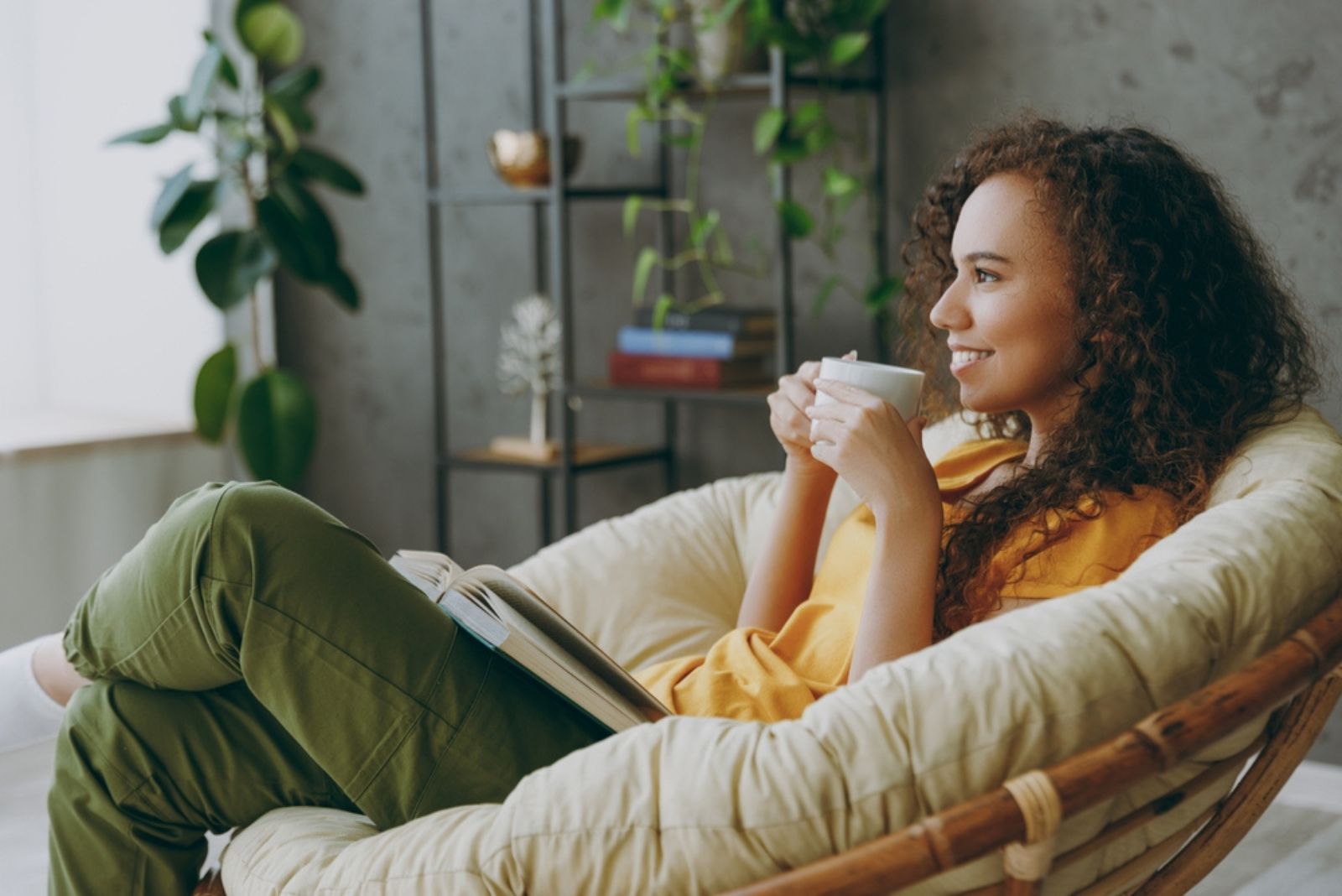 junge Frau mit Tasse geniesst ihr Zuhause