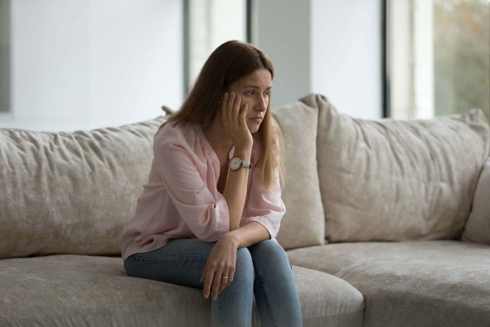 traurige Frau sitzt auf der Couch